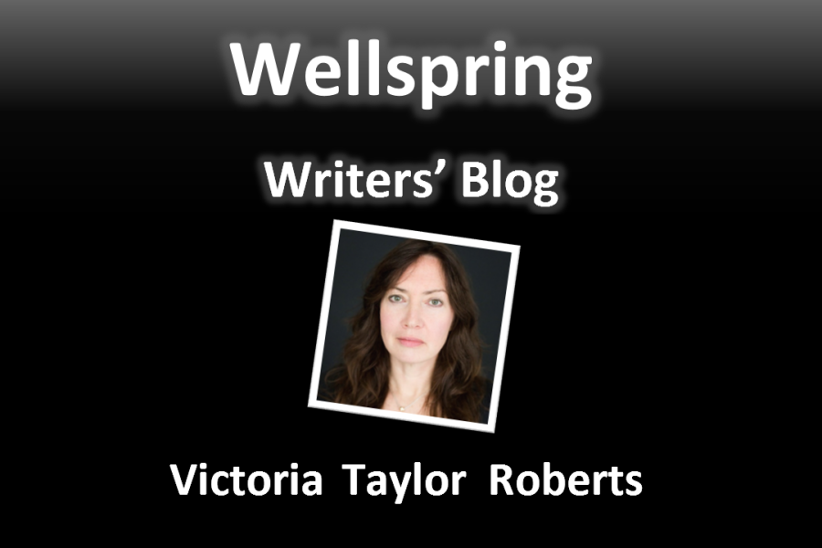 White letters on black background read 'Wellspring Writers' Blog'. Underneath a framed portrait photo of a woman with long wavy brown hair, green eyes, pale skin and rosy cheeks. Underneath the photo, the name Victoria Taylor - Roberts is written in white letters.