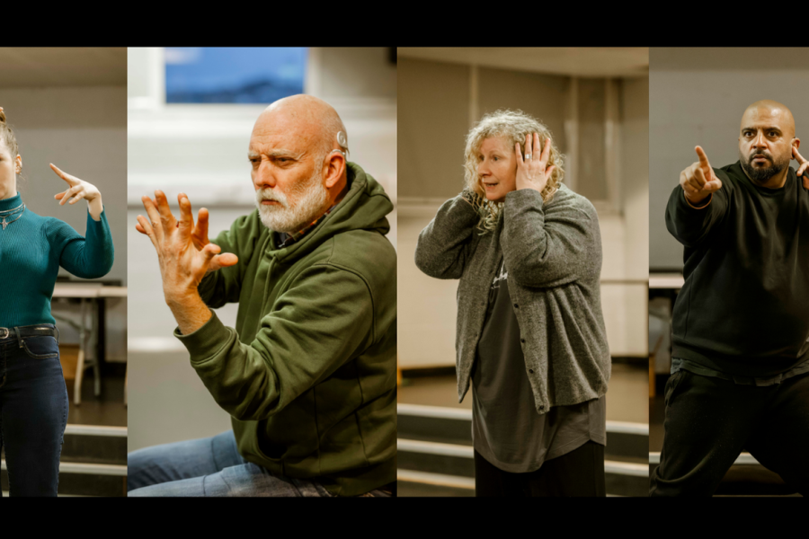 A composite photo of four people performing in a rehearsal room. From left to right: A blonde woman holds her hand wide open against her forehead, palm facing outward. A man with a grey beard looks intensely at his raised hands, his fingertips barely touching. A blonde woman with curly hair covers her ears with both hands. A man with a black beard points intensely beyond the camera with one hand, while the other hand touches his ear.
