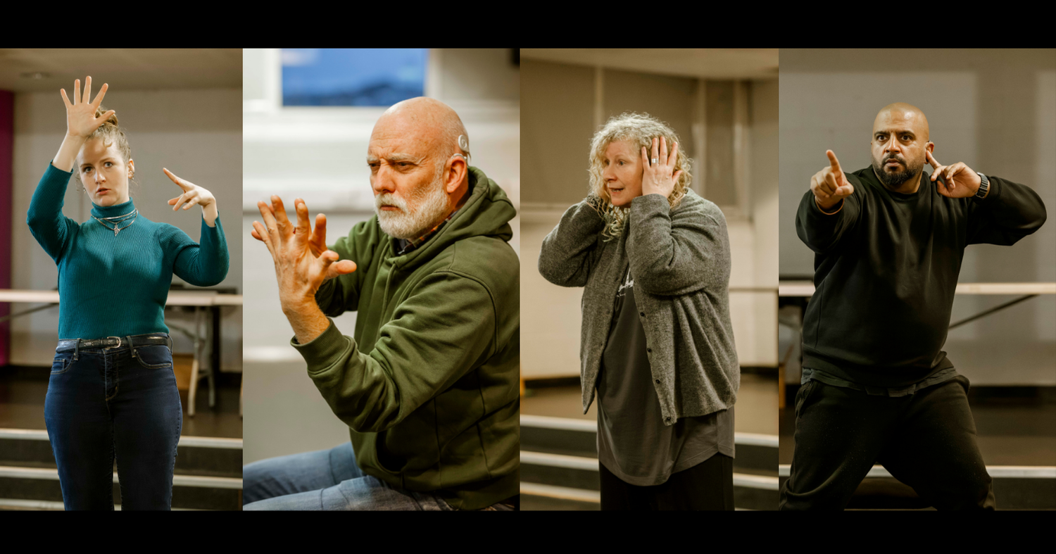 A composite photo of four people performing in a rehearsal room. From left to right: A blonde woman holds her hand wide open against her forehead, palm facing outward. A man with a grey beard looks intensely at his raised hands, his fingertips barely touching. A blonde woman with curly hair covers her ears with both hands. A man with a black beard points intensely beyond the camera with one hand, while the other hand touches his ear.